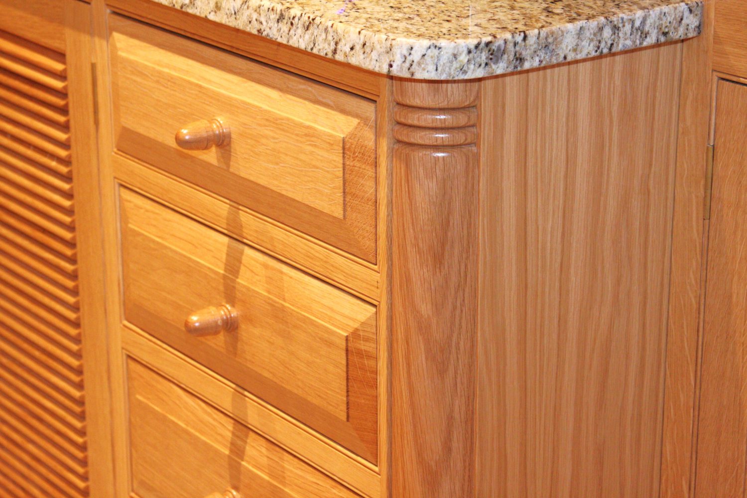 Quartered corner columb and raised and fielded drawer fronts with acorn knobs