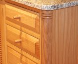 Quartered corner columb and raised and fielded drawer fronts with acorn knobs